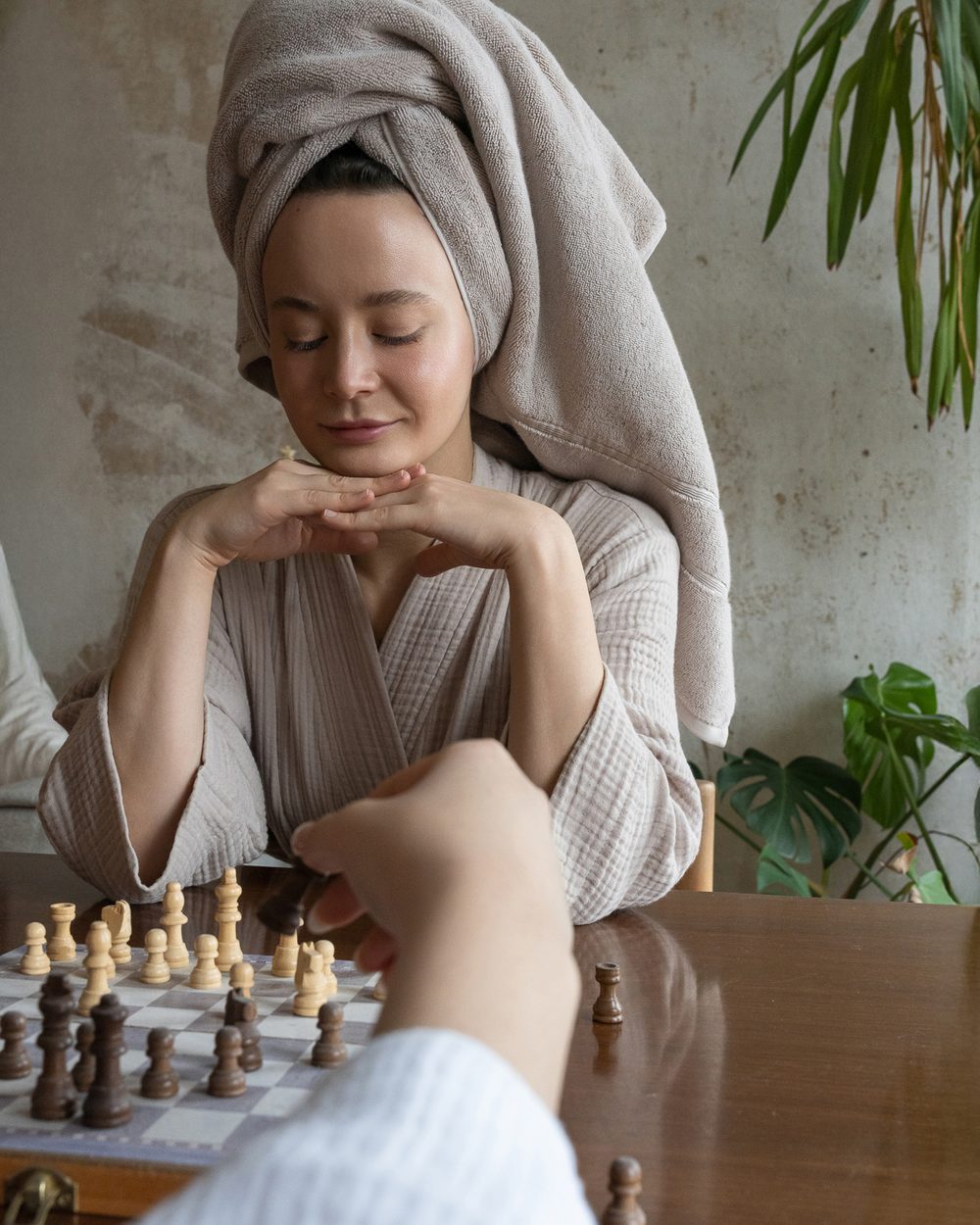 A woman in a Capyhome robe with her hair wrapped in a towel, smiling at home