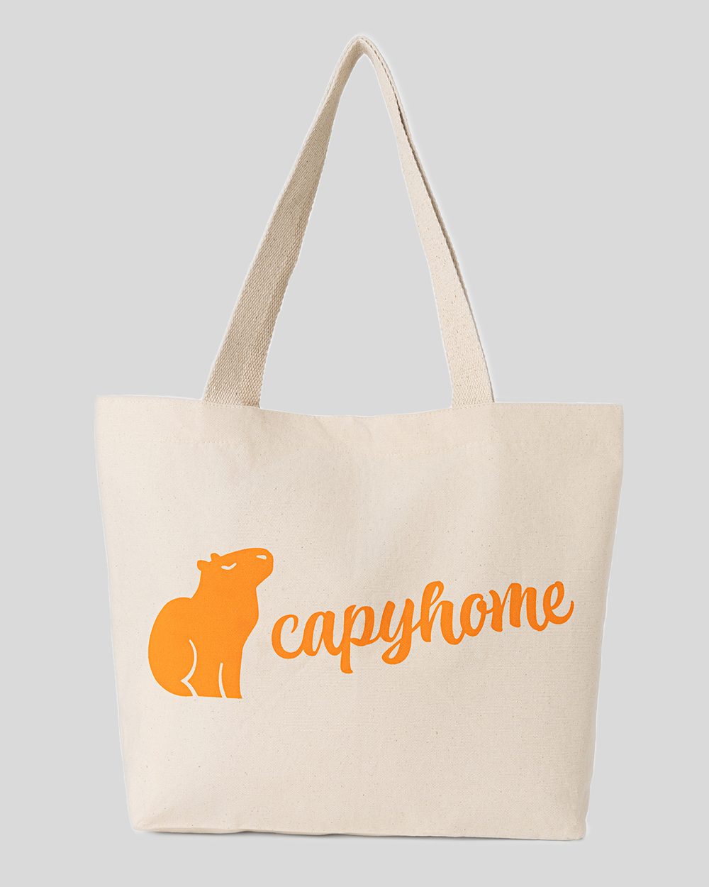 Natural canvas tote bag with the orange capyhome capybara logo, front view